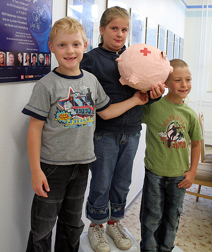 Max Szymanowski (7), Kassandra Böcker (9) und Maxemilia Meißner (7) sind Schüler der Klasse U2. Sie haben mit der Spenden das DRK Sparschwein gefüllt und warten nun auf die Sportgeräte. Max Szymanowski (7), Kassandra Böcker (9) und Maxemilia Meißner (7) sind Schüler der Klasse U2. Sie haben mit der Spenden das DRK Sparschwein gefüllt und warten nun auf die Sportgeräte.