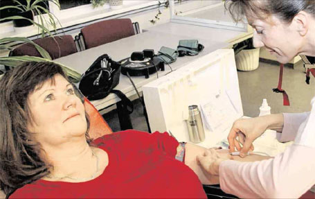 Schwester Anja vom DRK-Blutspendedienst zapft Gaby Kühn aus Sagard nach einer ärztlichen Untersuchung etwa 500 Milliliter Blut ab