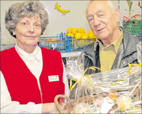 Dr. Klaus Götz, stellvertretender Vorstandsvorsitzender des DRK-Kreisverbandes, überreicht Helga Petersdorf einen großen Präsentkorb zum Abschied