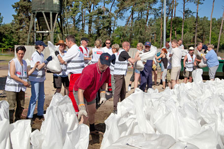 Seite an Seite mit den Anwohnern verladen die Freiwilligen Sandsäcke.